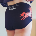 Black shorts with a red horse design and 'Year of The Horse' text on a plain background